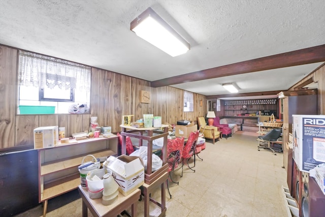 basement featuring a textured ceiling and wooden walls