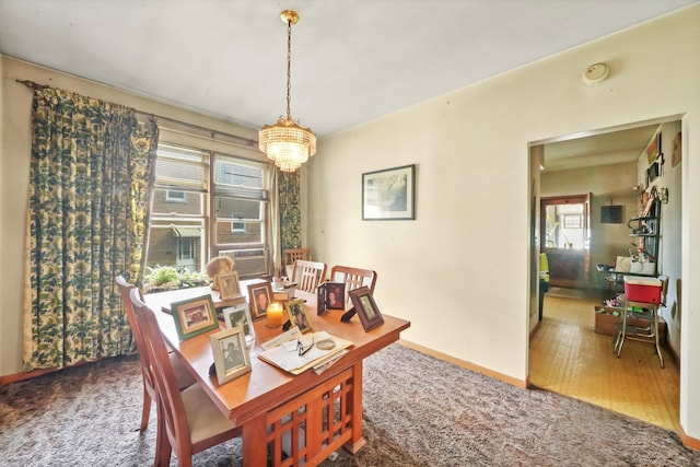 dining area with hardwood / wood-style flooring and an inviting chandelier