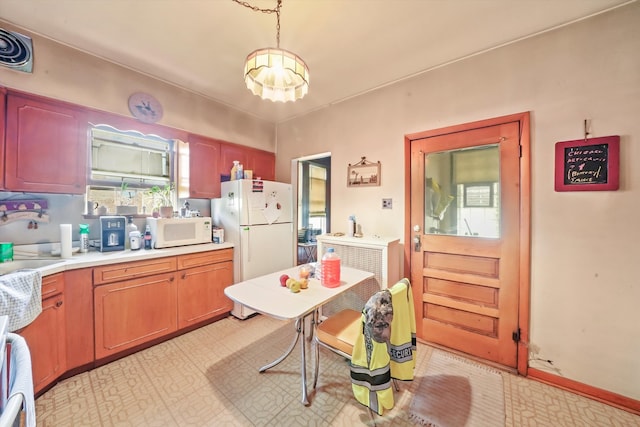 kitchen with decorative light fixtures, white appliances, and a chandelier