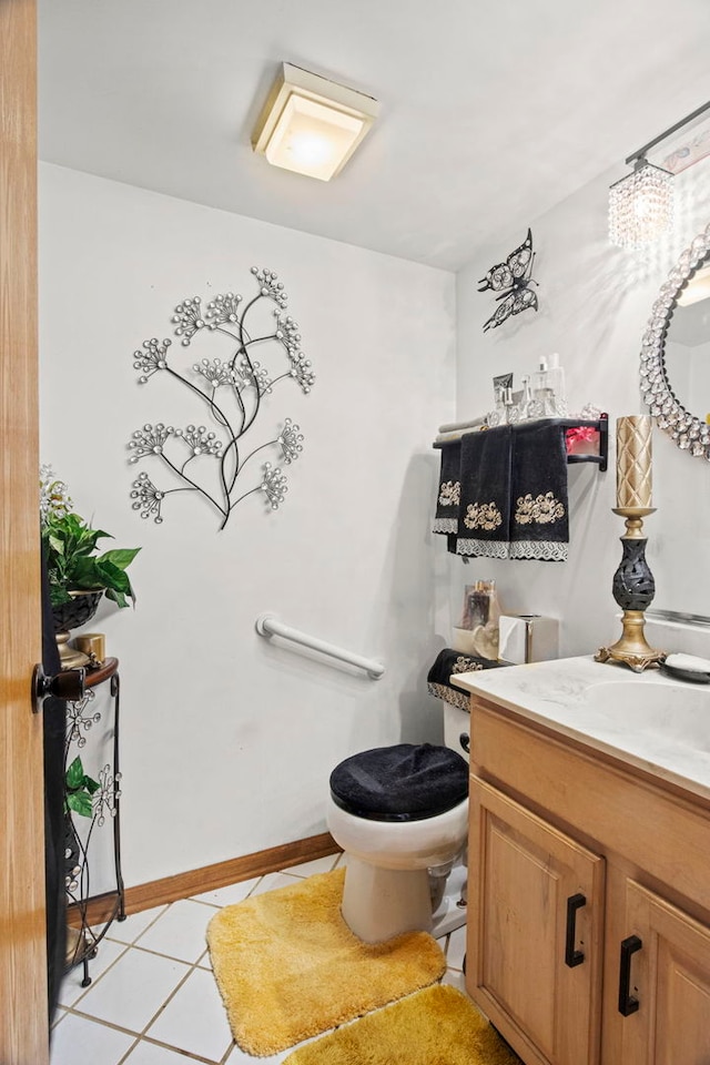 bathroom featuring tile patterned flooring, toilet, vanity, and baseboards