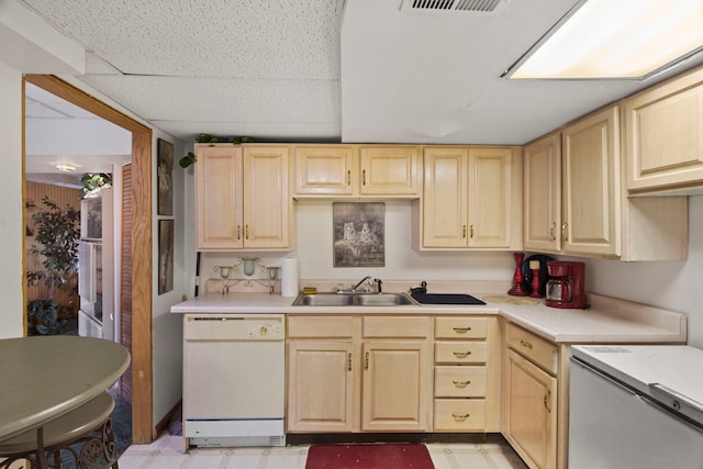 kitchen with light brown cabinets, visible vents, a sink, light countertops, and dishwasher