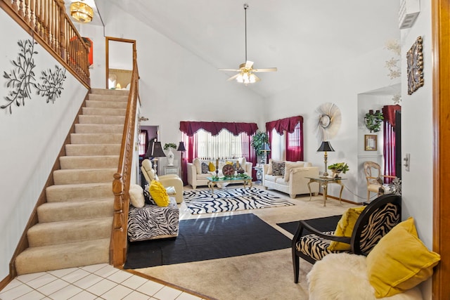 living area featuring high vaulted ceiling, stairs, and a ceiling fan