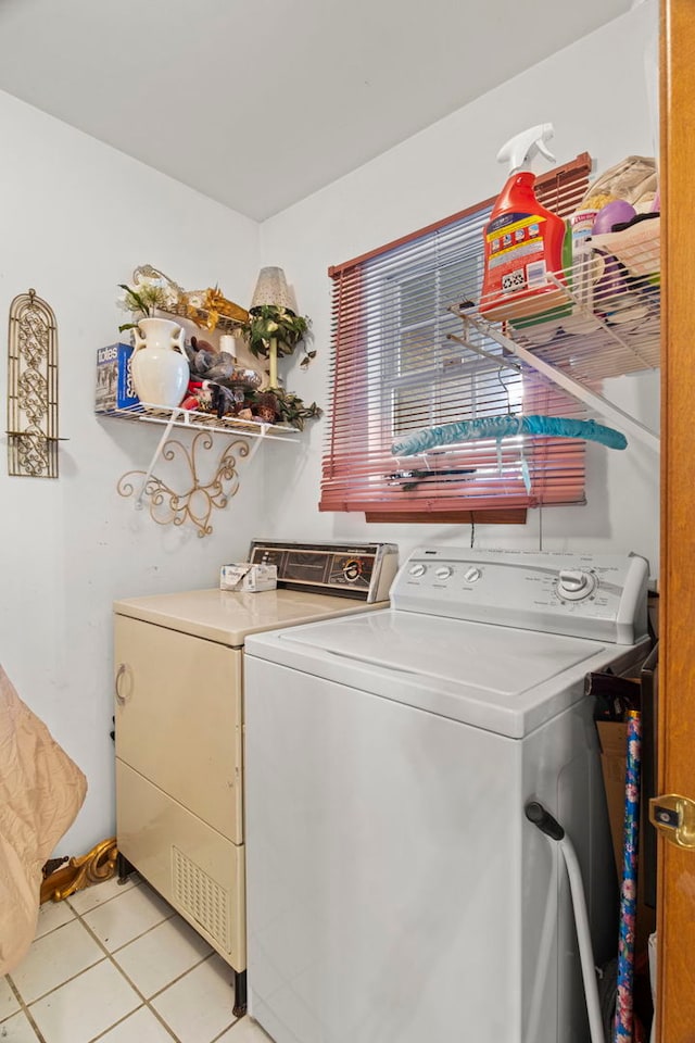 clothes washing area with washer and dryer, laundry area, and light tile patterned floors