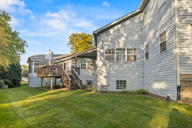 back of house with a lawn, a wooden deck, and stairs