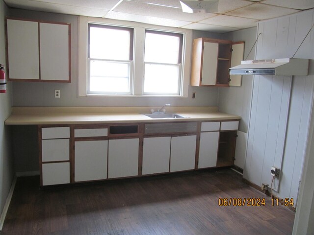 kitchen featuring dark wood-type flooring, a paneled ceiling, and white cabinets