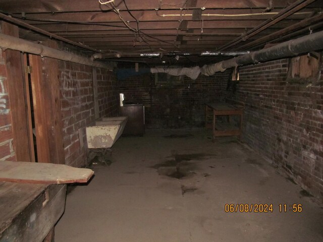 basement featuring sink and brick wall