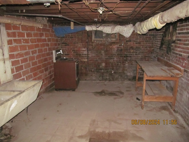 basement featuring brick wall