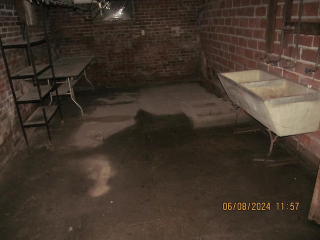 unfinished below grade area featuring a sink and brick wall