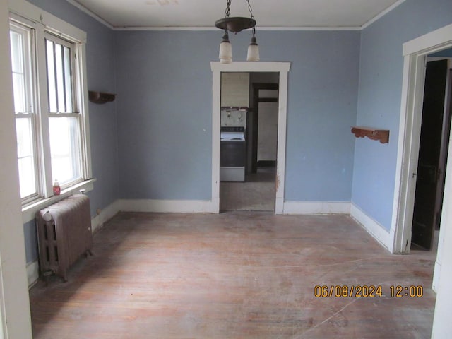 unfurnished dining area featuring radiator heating unit, baseboards, and crown molding