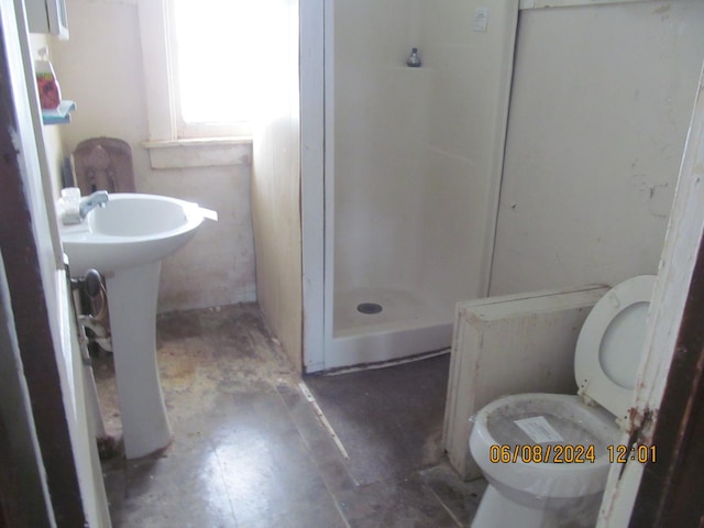 bathroom featuring walk in shower and toilet