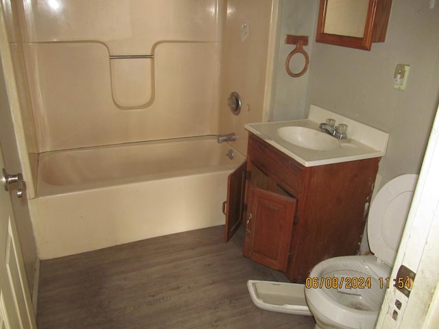 bathroom featuring toilet, vanity, wood finished floors, and shower / bathing tub combination