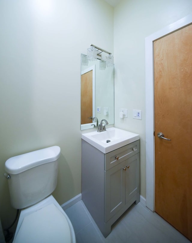 bathroom featuring tile patterned flooring, toilet, and vanity