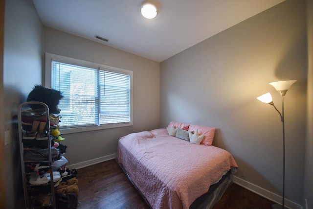 bedroom with vaulted ceiling and dark hardwood / wood-style flooring