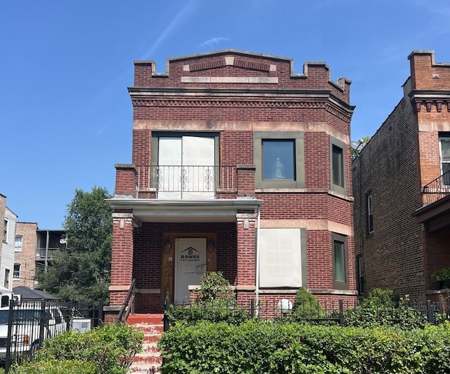 view of front of property featuring brick siding, fence, and a balcony