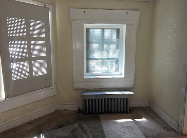 empty room featuring baseboards and radiator heating unit