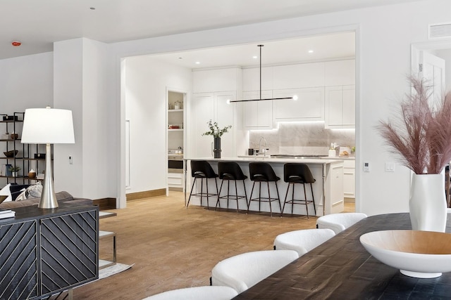 living room with baseboards, visible vents, light wood-style flooring, and recessed lighting