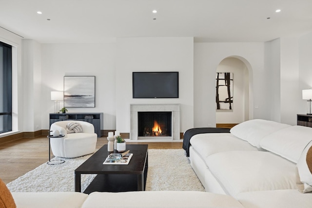 21 N May St Unit 402, Chicago, IL 60607 - living area featuring arched walkways, wood finished floors, recessed lighting, a warm lit fireplace, and baseboards