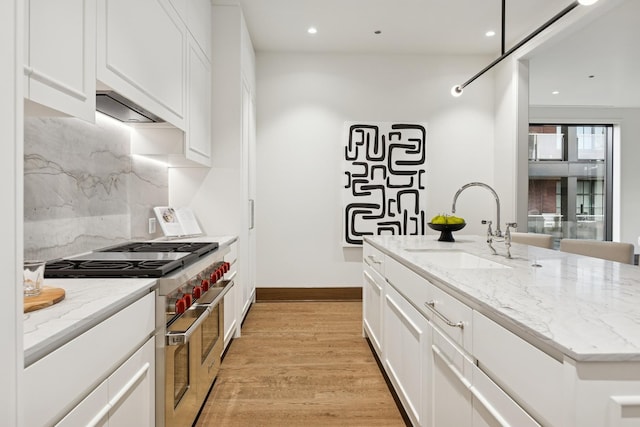 21 N May St Unit 402, Chicago, IL 60607 - kitchen featuring double oven range, a sink, decorative backsplash, white cabinets, and light wood-style flooring