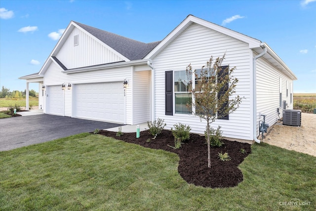 view of front of property with central air condition unit, a garage, and a front lawn