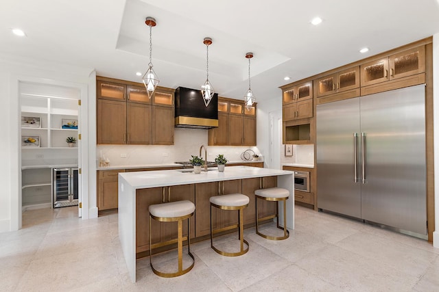 kitchen with stainless steel built in refrigerator, a raised ceiling, beverage cooler, and premium range hood