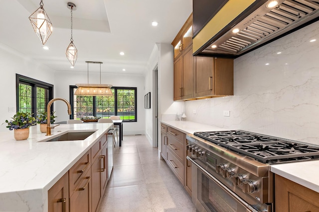 kitchen featuring light stone countertops, sink, hanging light fixtures, stainless steel appliances, and custom exhaust hood