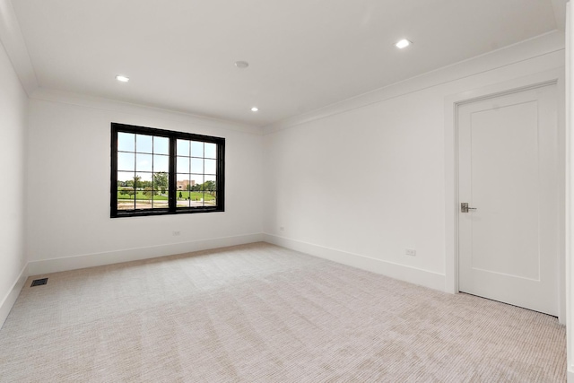 unfurnished room with ornamental molding, light carpet, visible vents, and baseboards