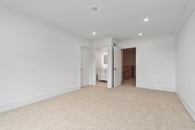 unfurnished bedroom with recessed lighting, ornamental molding, light carpet, ensuite bath, and baseboards