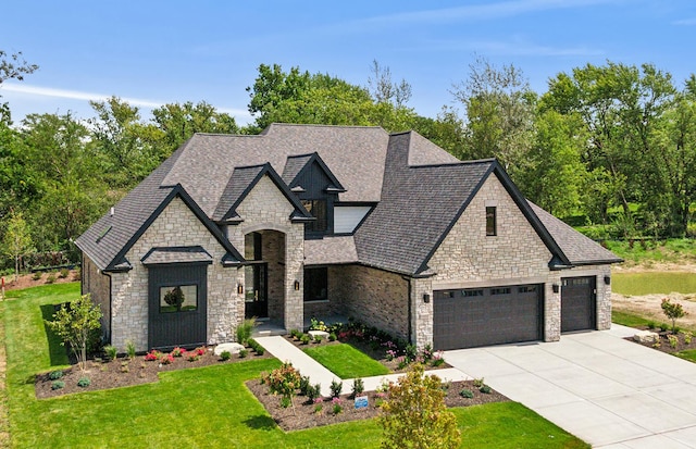 french country inspired facade featuring driveway, a shingled roof, and a front lawn