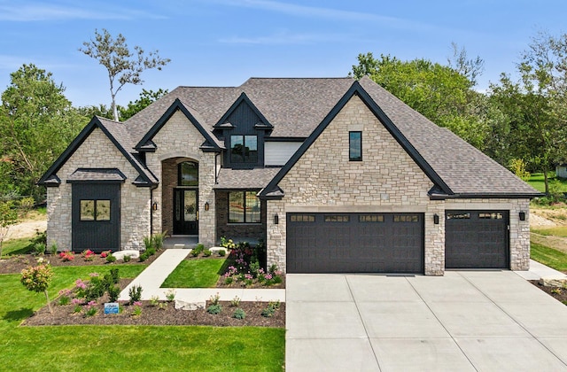 view of front of home featuring a shingled roof, a front yard, and concrete driveway