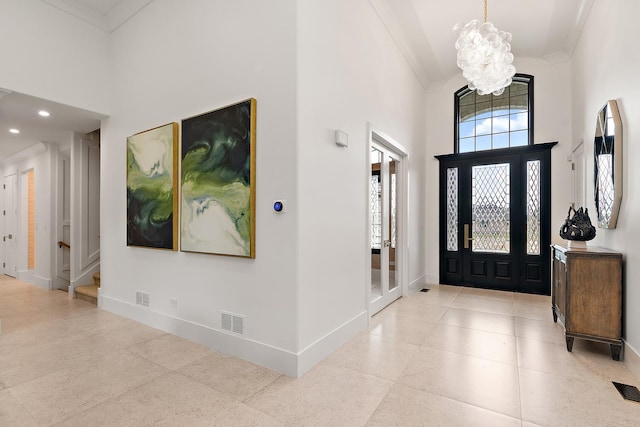 entryway featuring crown molding, a high ceiling, visible vents, and baseboards