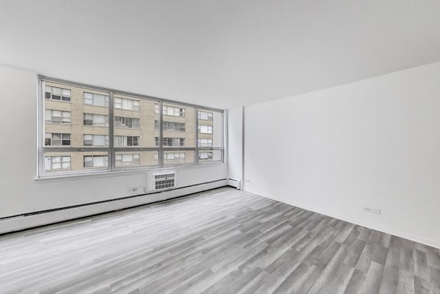 6171 N Sheridan Rd Unit 1508, Chicago, IL 60660 - spare room with wood finished floors, plenty of natural light, a baseboard heating unit, and baseboards