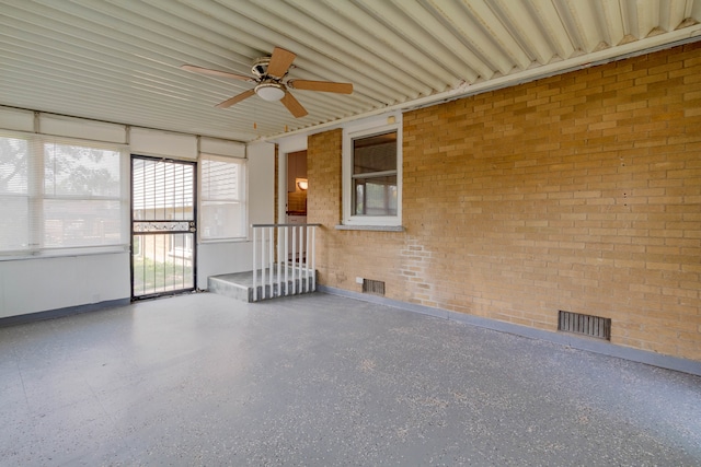 unfurnished sunroom featuring ceiling fan