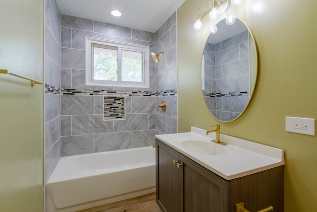 bathroom with tiled shower / bath combo, hardwood / wood-style flooring, and vanity