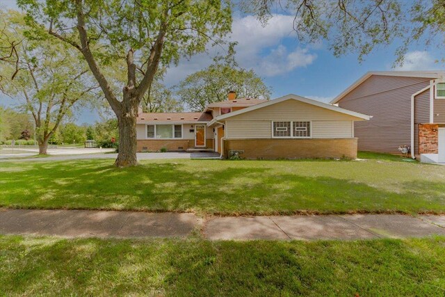 view of front of property featuring crawl space, brick siding, and a front yard