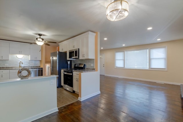 kitchen with stainless steel appliances, dark wood-type flooring, white cabinets, and tasteful backsplash