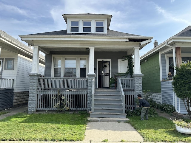 view of front of property featuring a shingled roof and a porch