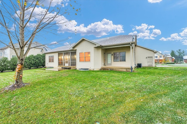 rear view of property featuring a sunroom, a yard, and central air condition unit