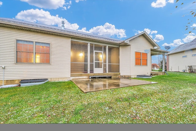 back of house featuring a lawn, a patio area, and a sunroom