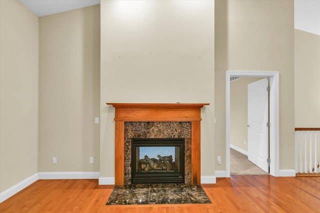 room details with a multi sided fireplace and wood-type flooring