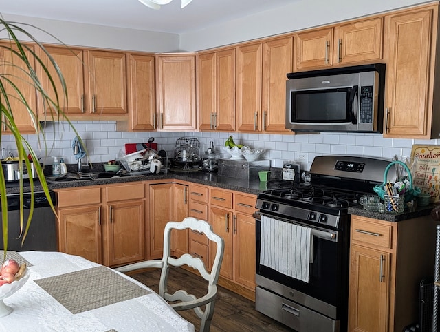 kitchen featuring backsplash, appliances with stainless steel finishes, dark wood-type flooring, and sink