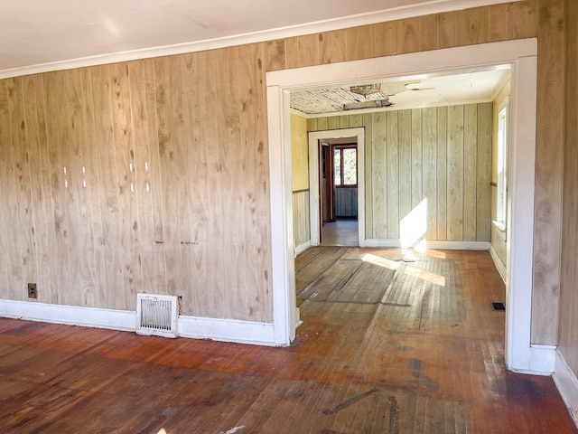 empty room featuring wood walls and hardwood / wood-style floors