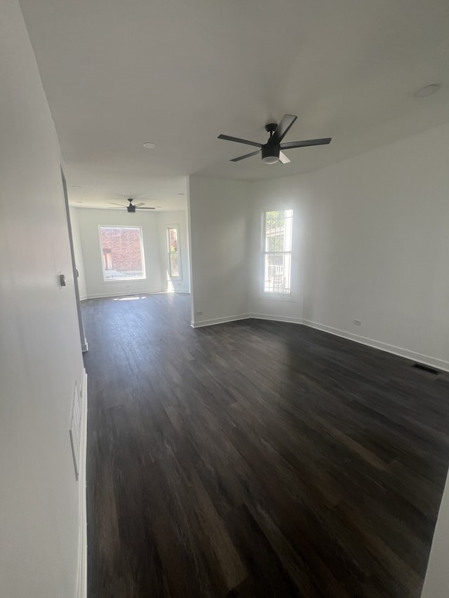 spare room with dark hardwood / wood-style flooring and ceiling fan