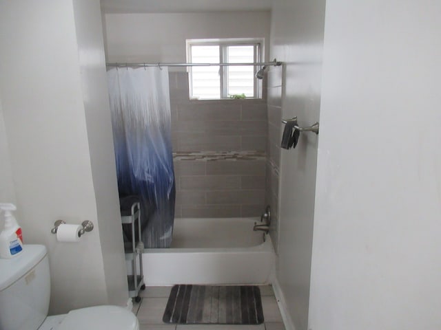 bathroom with tile patterned flooring, shower / tub combo, and toilet