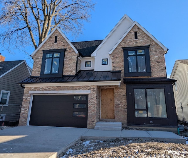 view of front of property with a garage, brick siding, driveway, and a standing seam roof