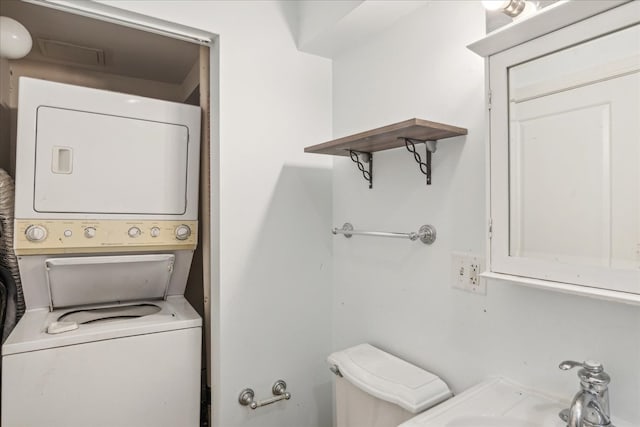 clothes washing area featuring stacked washing maching and dryer and sink