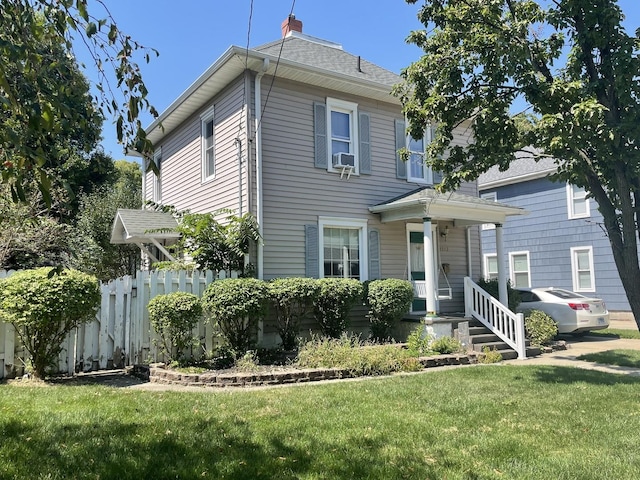 view of front of property with a chimney, fence, a front lawn, and cooling unit