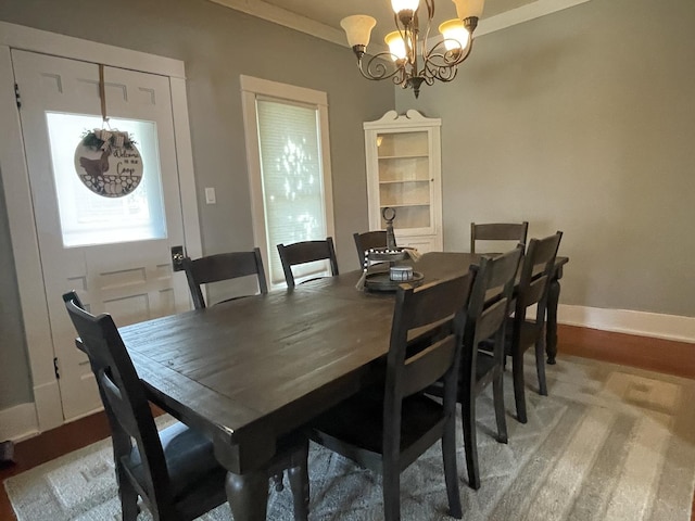 dining area with a notable chandelier, baseboards, wood finished floors, and ornamental molding