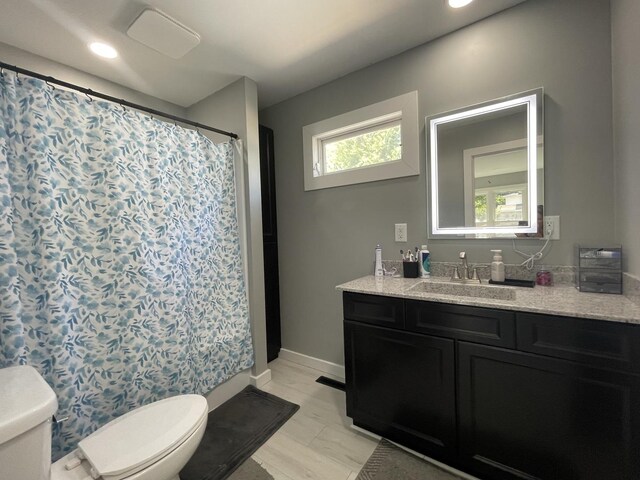 bathroom with a shower with shower curtain, vanity, and toilet