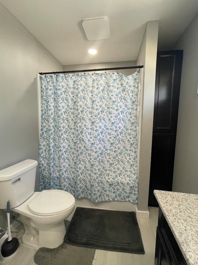 bathroom with a shower with shower curtain, toilet, and vanity