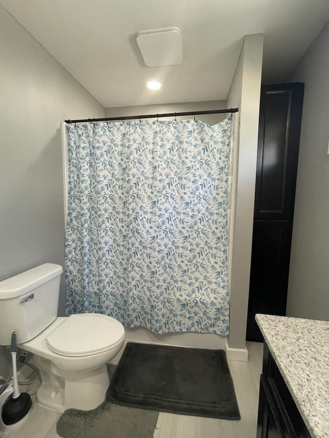 bathroom featuring a shower with curtain, vanity, and toilet